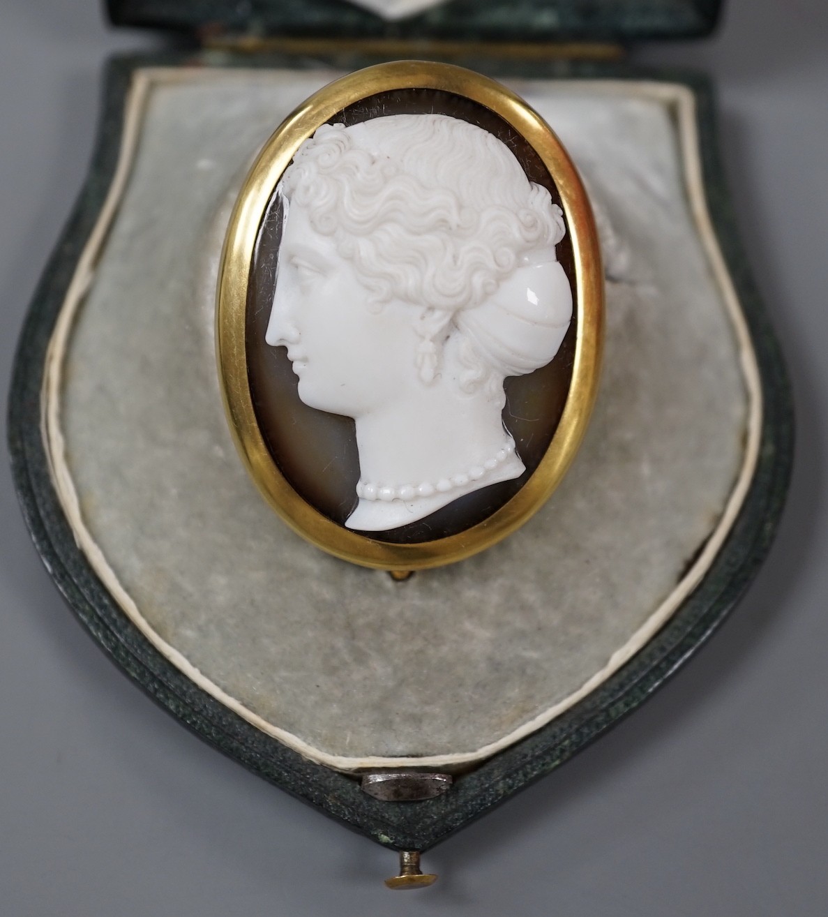 A Victorian yellow metal mounted agate cameo oval brooch, carved with the head of a lady to dexter, 41mm, in fitted initialled leather case.